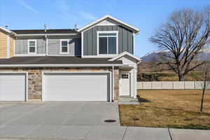 Craftsman house with stone siding, board and batten siding, an attached garage, and concrete driveway