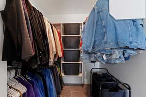 Walk in closet featuring dark carpet