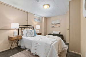 Carpeted bedroom featuring wood walls