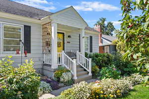 Property entrance featuring a porch, a chimney, and a shingled roof
