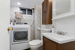 Bathroom with washer / clothes dryer and vanity