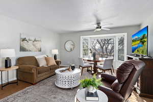 Carpeted living area featuring baseboards and ceiling fan