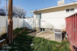 View of side of property featuring a gate, a fenced backyard, and a patio area