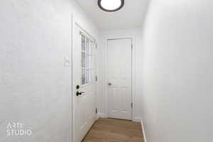 Entryway with wood finished floors and a textured wall