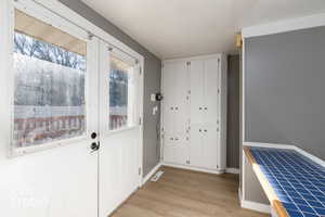 Doorway to outside with wood finished floors and baseboards