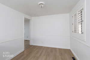Spare room featuring wood finished floors and baseboards