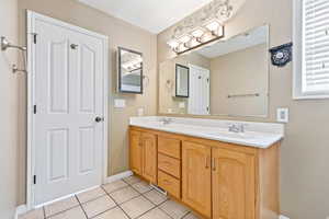 Full bath with double vanity and light tile patterned flooring
