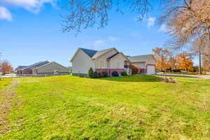 Back of house featuring a garage, driveway, stucco siding, and brick siding