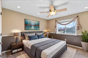 Bedroom with light carpet, ceiling fan, and recessed lighting
