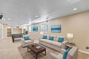 Living area with light carpet, recessed lighting, a textured ceiling, and billiards table
