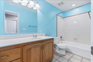 Bathroom with vanity, light tile patterned floors, and bathtub / shower combination