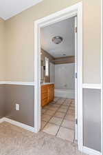 Full bathroom with vanity, light carpet, bathing tub / shower combination, and light tile patterned floors