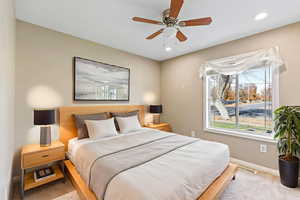 Carpeted bedroom with a ceiling fan and recessed lighting