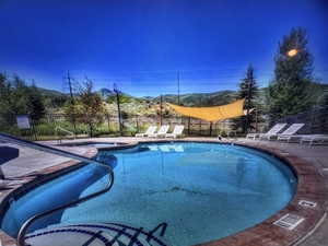 Community pool with a patio area and a mountain view