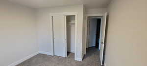 Unfurnished bedroom featuring light colored carpet and a closet