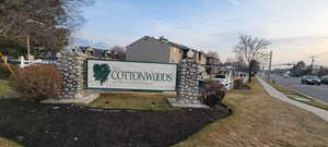 Community sign featuring a residential view and a lawn