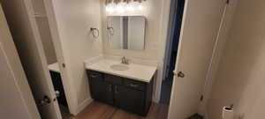Half bath featuring vanity and wood finished floors