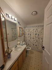 Full bath with a shower with curtain, a textured ceiling, vanity, light floors, and a textured wall