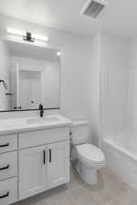 Full bath with vanity, light tile patterned floors, and tub / shower combination