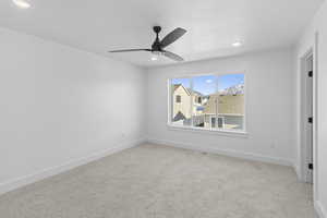 Unfurnished bedroom featuring light carpet, a ceiling fan, and recessed lighting