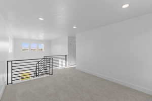 Carpeted empty room featuring recessed lighting and baseboards