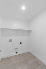Washroom with hookup for an electric dryer, washer hookup, and light tile patterned flooring