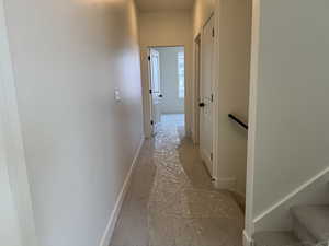 Hallway with baseboards and an upstairs landing