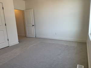 Unfurnished bedroom featuring carpet floors and baseboards