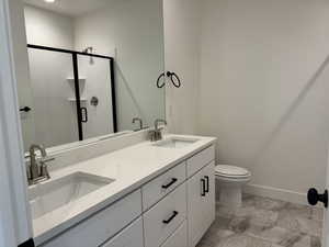Full bath with double vanity and a stall shower