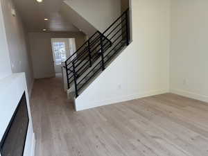 Stairway featuring wood finished floors, recessed lighting, and a fireplace
