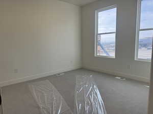 Carpeted empty room with baseboards