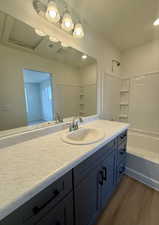 Bathroom with vanity, dark wood finished floors, and bathtub / shower combination