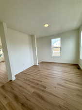 Spare room featuring light wood-style floors and a textured ceiling