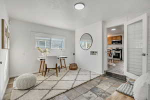Interior space featuring baseboards and stone tile floors