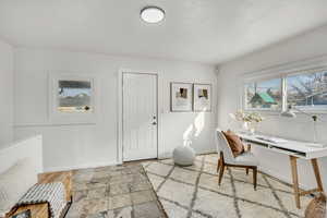 Home office with healthy amount of natural light and stone tile flooring
