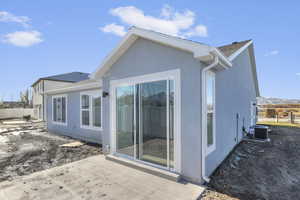 Back of house with stucco siding, a patio, and a shingled roof