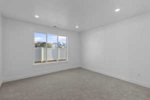 Empty room featuring light carpet and recessed lighting