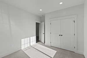 Unfurnished bedroom featuring carpet flooring, a closet, and recessed lighting