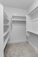 Walk in closet with light carpet