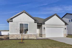 View of front of house with stone siding, concrete driveway, and a garage