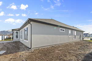 View of home's exterior with roof with shingles and a mountain view