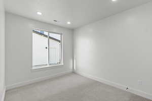 Carpeted empty room featuring baseboards and recessed lighting