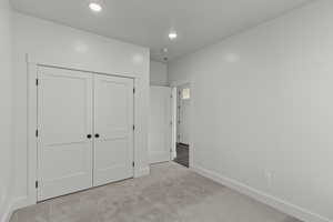 Unfurnished bedroom with carpet floors, a closet, and recessed lighting