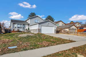 View of front of property with brick siding, concrete driveway, and an attached garage