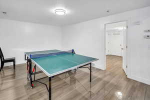 Game room featuring wood finish floors and a textured ceiling