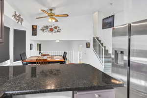 Kitchen featuring stainless steel fridge, dark stone countertops, and ceiling fan