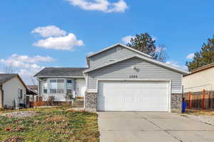 View of front of home with brick siding, concrete driveway, and an attached garage