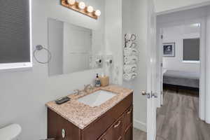 Ensuite bathroom with vanity and light wood-type flooring