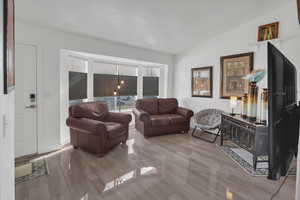 Living room featuring lofted ceiling and wood finish floors