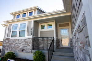 Property entrance featuring stone siding and a porch